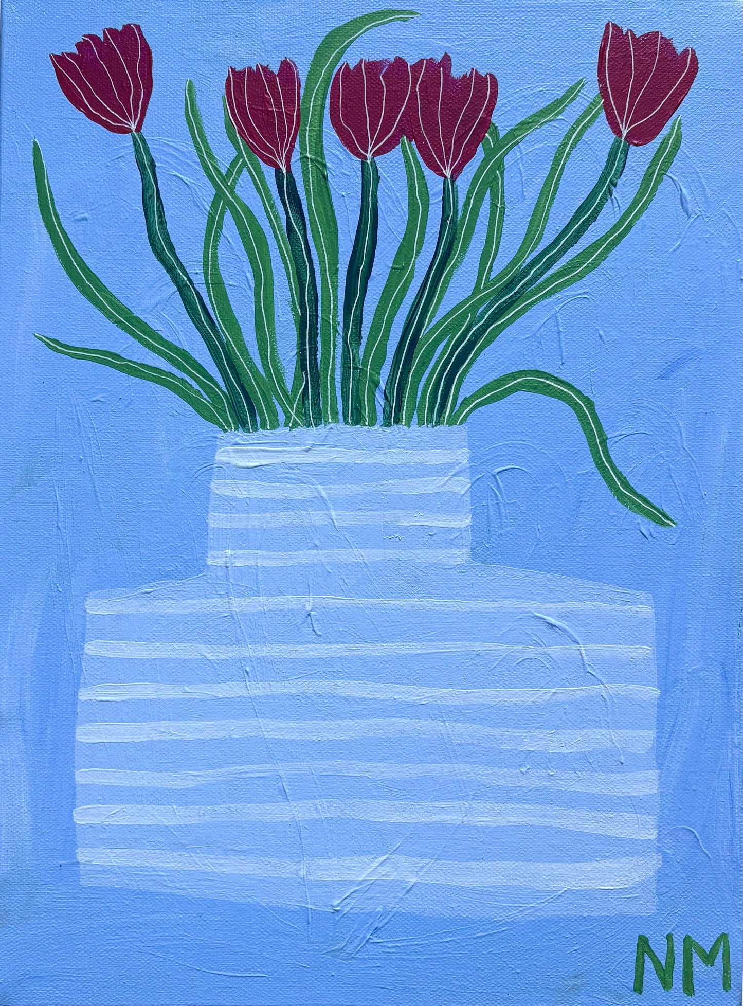 Red tulips in blue vase.