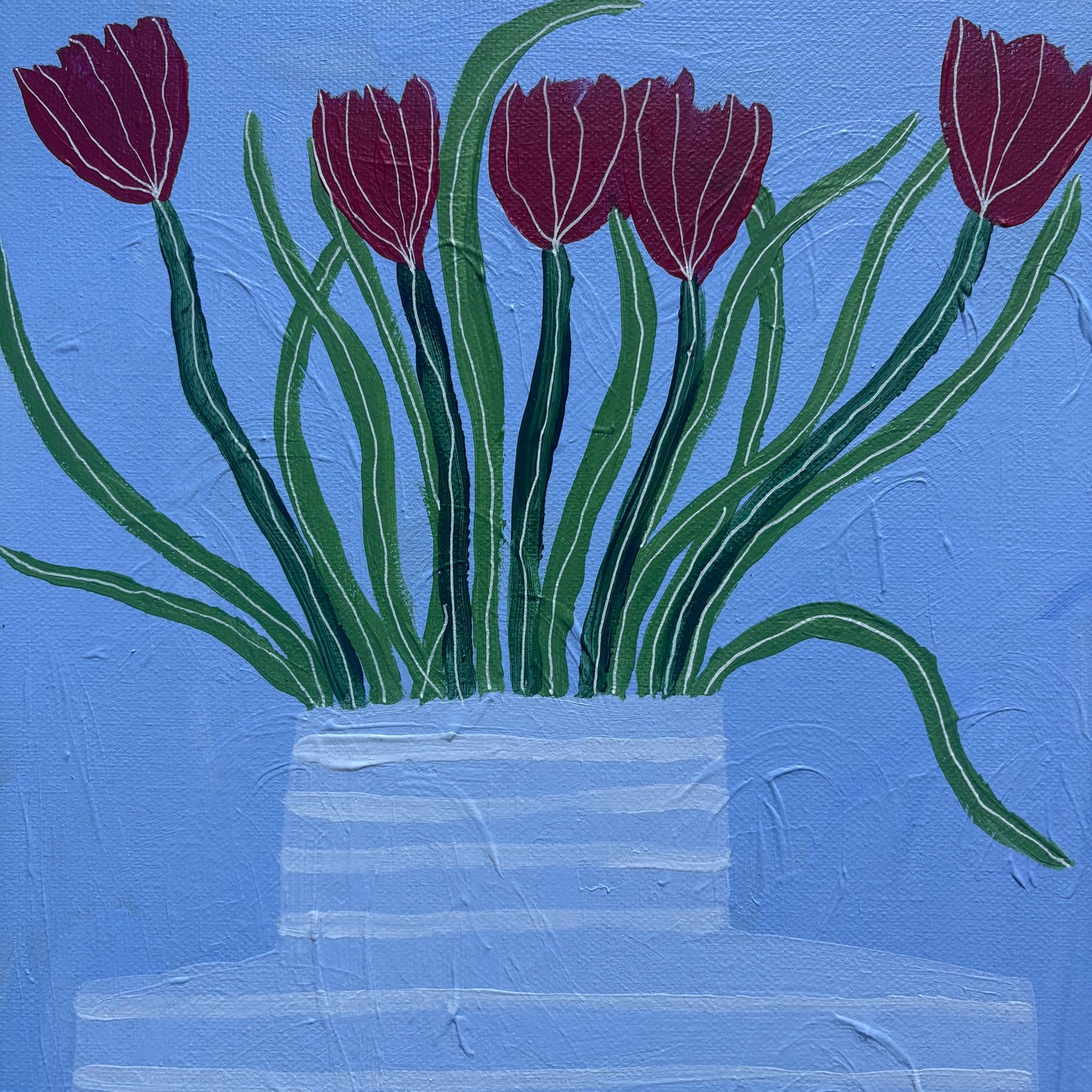 Red tulips in blue vase.