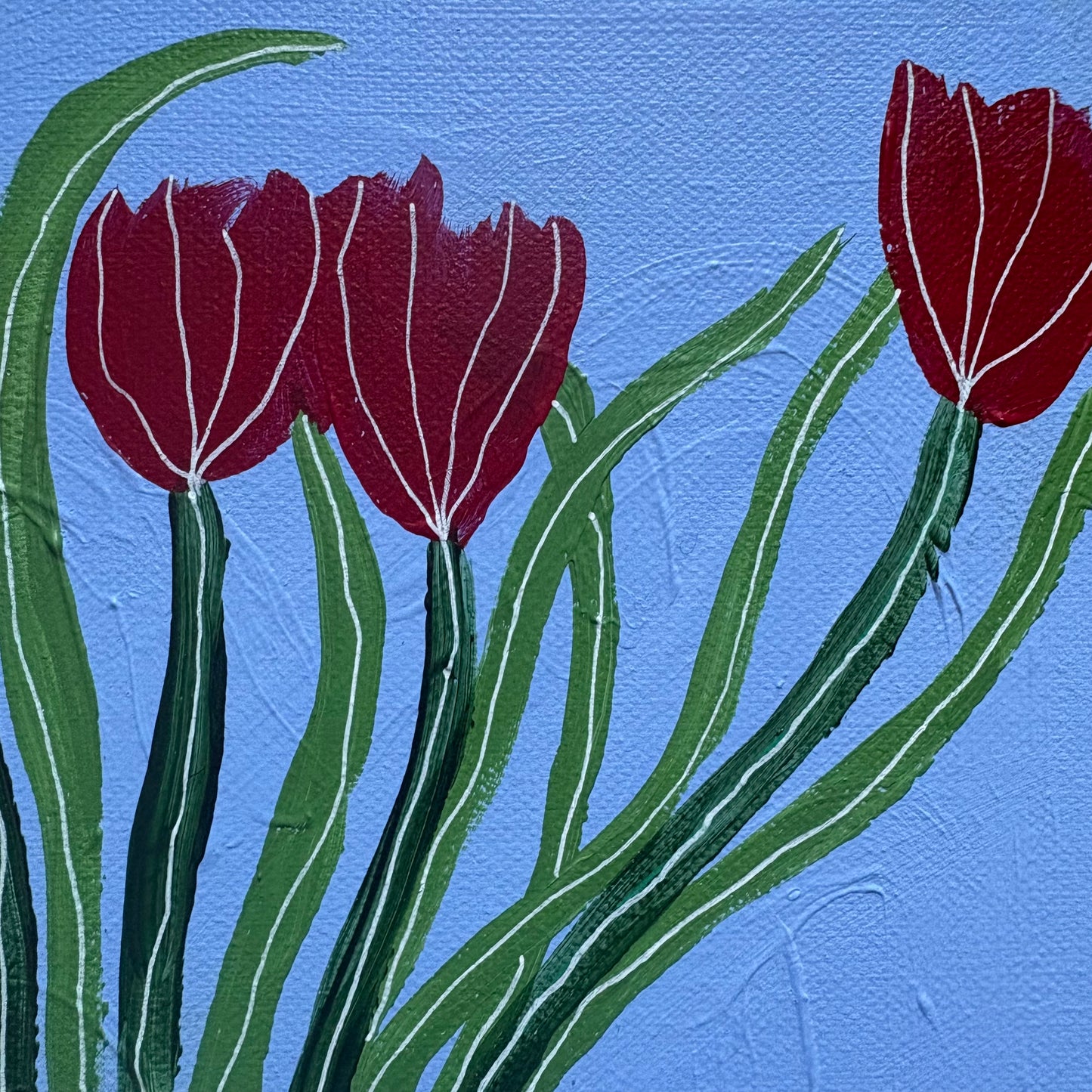 Red tulips in blue vase.